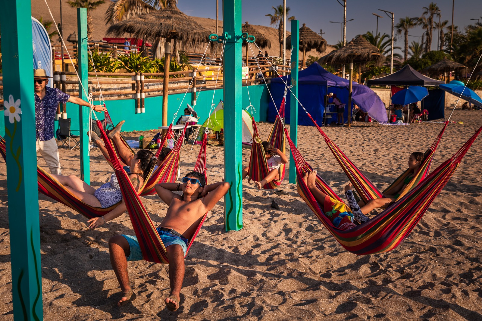 Bañistas toman un merecido descanso en las cómodas hamacas de playa La Lisera
